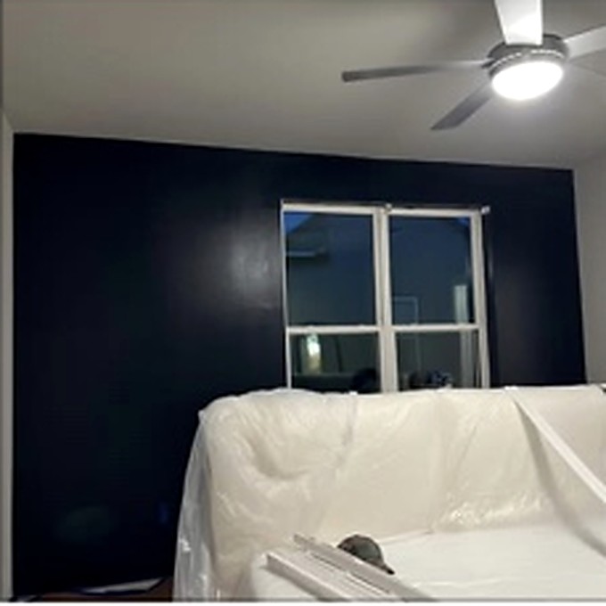 Interior room showing dark accent wall and protected furniture